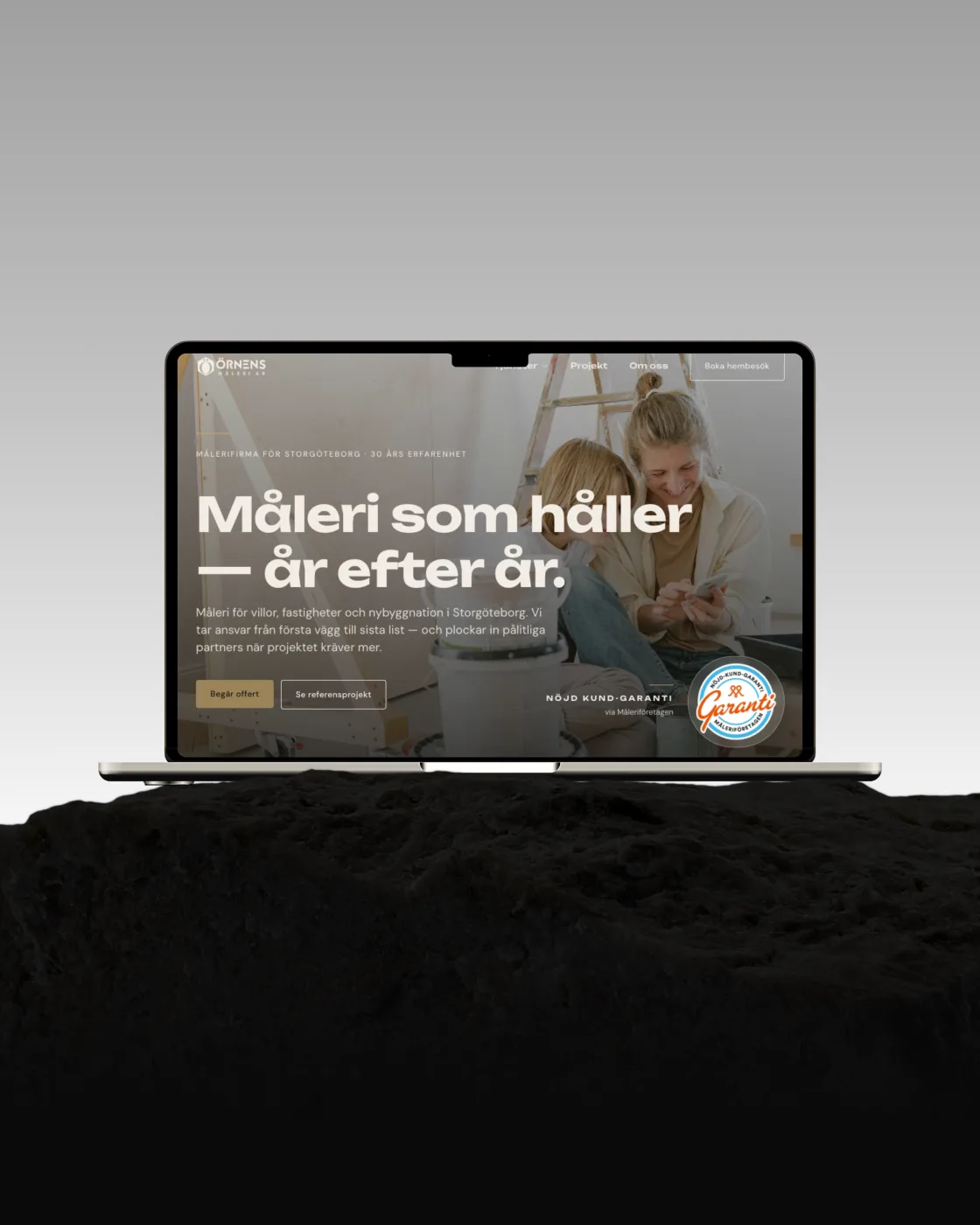 Örnens Måleri — hemsida byggd av Binici, i en laptop på en sten